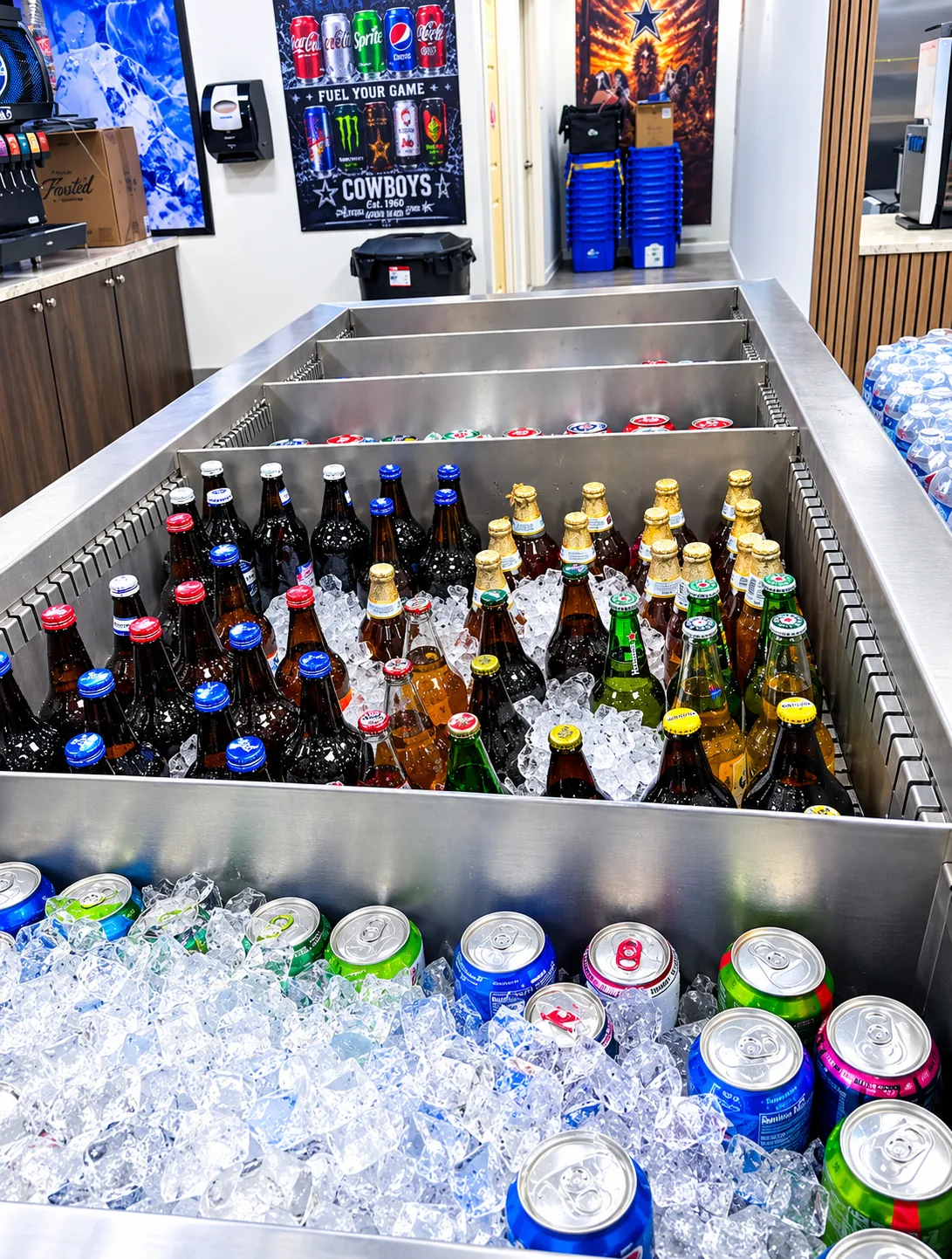 Stainless ice tub packed with ice-cold bottles and cans of sodas and drinks